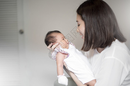 怀里抱着婴儿的年轻女子背景图片