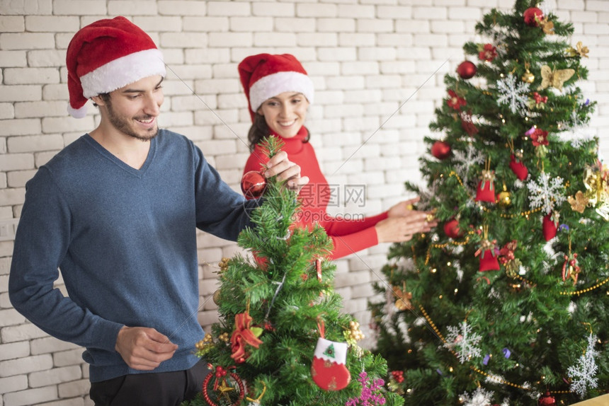 情侣在家一起装饰圣诞树图片