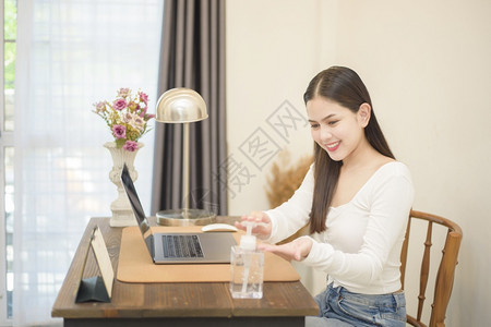 女人用洗净剂凝胶把手放在工作桌上图片