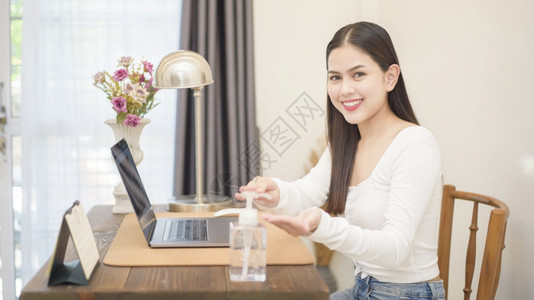 女人用洗净剂凝胶把手放在工作桌上图片