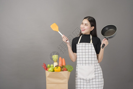 快乐的女子正在准备健康的食物做饭图片