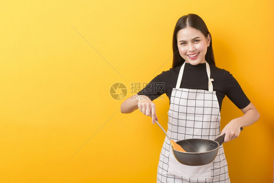 黄色背景的女厨师快乐肖像图片