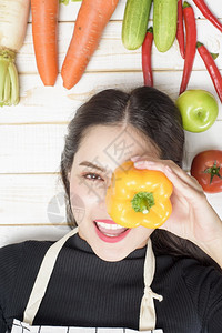 白木背景的杂货袋里有蔬菜的妇女图片