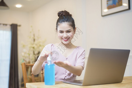 在家用酒精凝胶工作的妇女图片