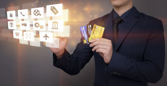 商人持有信用卡在数字虚拟屏幕上分析银行金融数据图片