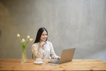 美丽的女商人在咖啡店用笔记本电脑工作图片