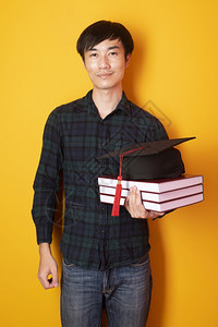 大学男生拿着毕业帽和书本图片