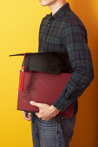 大学男生拿着毕业帽和书本图片