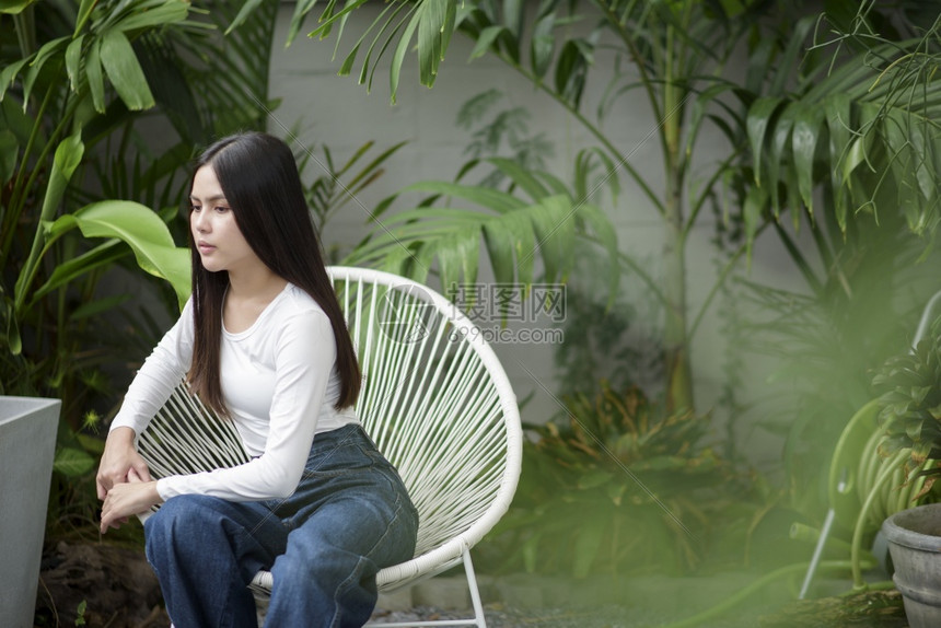 一名身着白布和咖啡馆外绿色植物的年轻女一名身着绿色植物的年轻女身着白布和绿色植物的年轻女图片