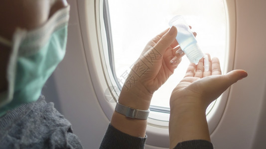 飞机上的乘客在给自己的手消毒图片