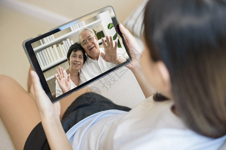 年轻女使用平板视频呼叫祖父母一起了解健康知识图片
