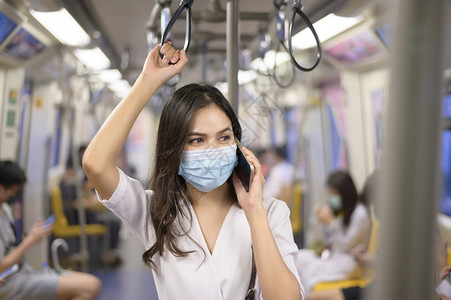 一名年轻妇女在地铁中戴保护面具在公用19号保护中戴面具在安全旅行中戴保护面具在安全运输中大流行病概念下穿保护面具一名年轻妇女在地图片