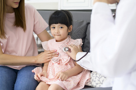 一名持有听诊器的女医生正在院与母亲一起检查个快乐女孩的医疗概念图片