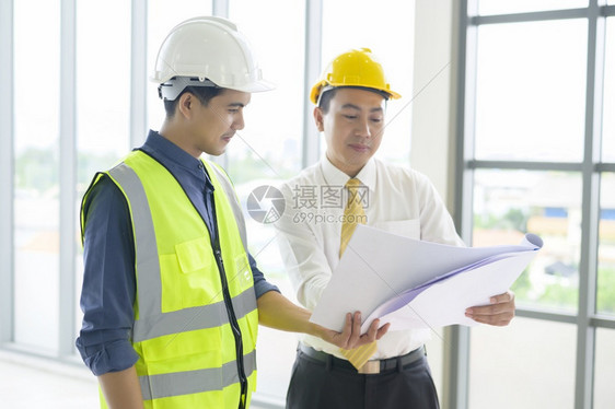 工程人员是具有办公室蓝图的分析建筑计划工程人员是具有办公室蓝图的分析建筑计划图片