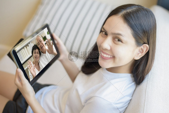 年轻女使用平板视频呼叫祖父母一起了解健康知识图片