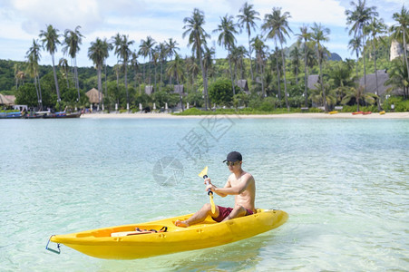 阳光明媚的一天个运动的年轻男子在海洋骑单艇图片