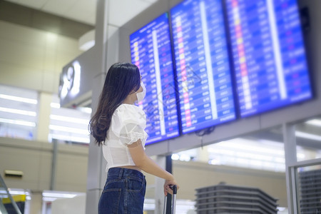 一名旅行妇女在国际机场佩戴保护面罩图片