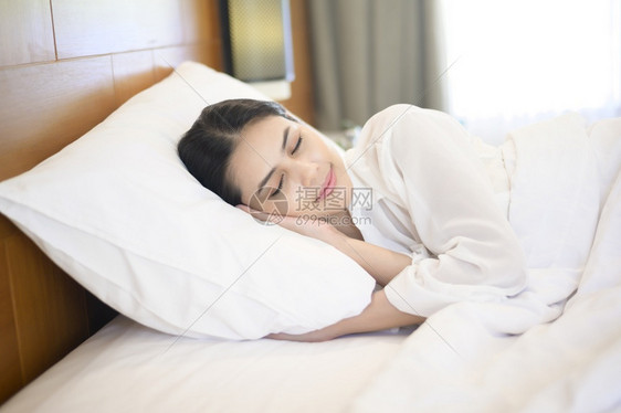 年轻美丽的女士在家床上睡觉图片