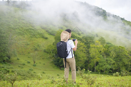 一个旅行者享受和放松美丽的绿色山景在雨季热带气候图片