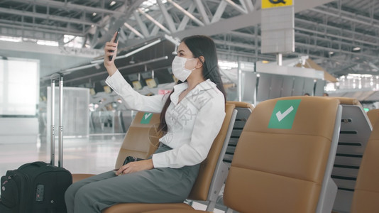 一名商业妇女在国际机场佩戴保护面具在新冠大流行下的家庭旅安全社会不和协议新正常旅行概念下的家庭旅行图片