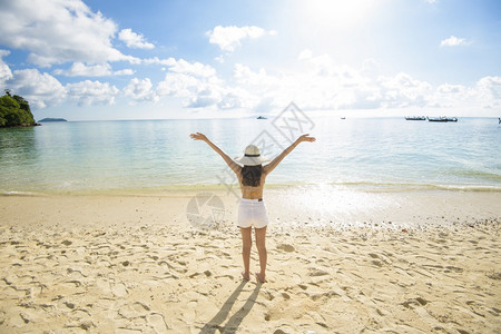 一个快乐的美丽女人在黄色比基尼享受和放松在海滩夏天和节假日的概念图片