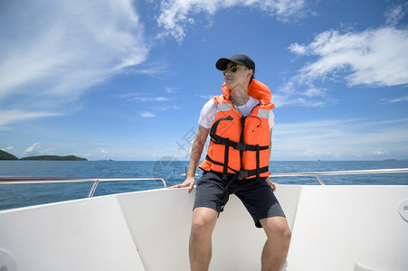 一个穿救生衣的游客在快艇上享受和放松对海洋山的景色美在后海中享受和放松穿救生衣的游客在快艇上享受和放松对海洋山的景色美在后海中享图片