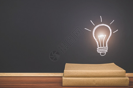 在黑板上读书的概念灯泡符号代表一个想法背景图片