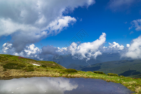 清晰的阿尔卑斯湖有蓝云天空的反射图片