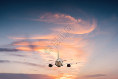 日落时空中飞机在天上飞翔图片