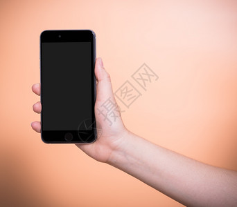 持有移动智能手机的女加上橙色背景的空白屏幕图片