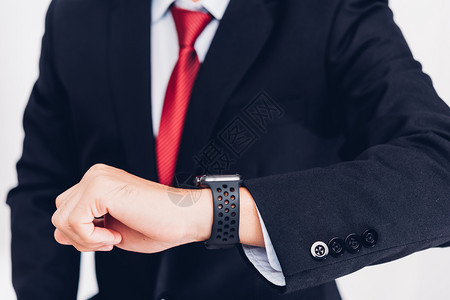 生意人穿得着手表的聪明智慧观察是现代技术设计孤立在白色背景上图片