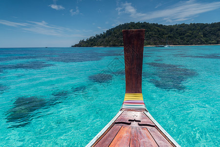 泰国木头长尾拖船朝泰国的热带安达曼海岸驶去图片