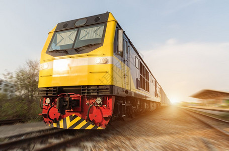 高速柴油火车在黄日运动模糊的轨道上图片
