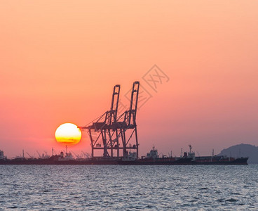 日落晚霞油轮和起重集装箱船背景