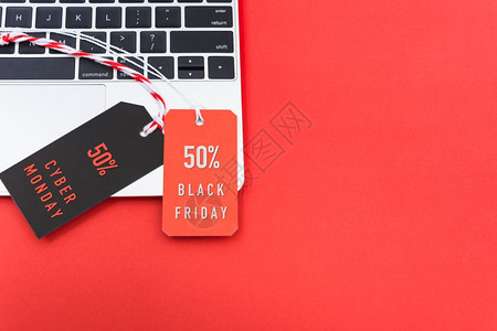 在线购物黑色星期五带红标签的文字和电脑上带有黑色标签的网络星期一文字复制空间红色背景图片