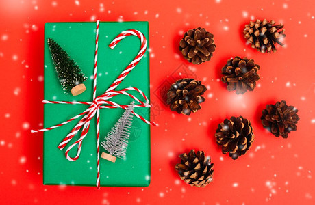 新年圣诞节的构成顶视礼物绿箱绳子的割缝和红背景绿色fir树枝以及复制空间图片