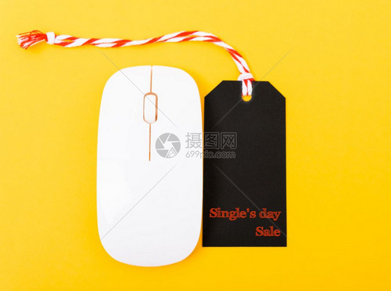 网上购物单人日销售的文本在黄色背景的计算机鼠标上贴黑签图片