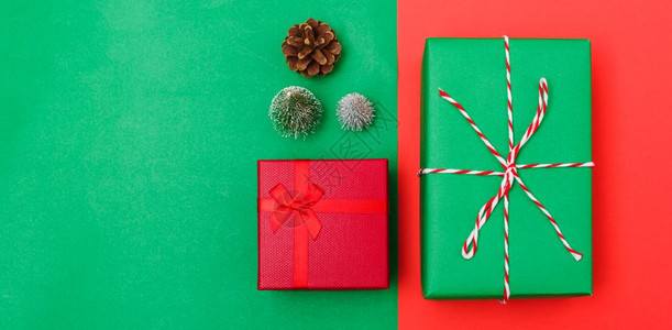 新年圣诞节的构成带有礼品盒的顶端观景绳子的割缝红绿树枝和色背景的树枝以及复制空间图片