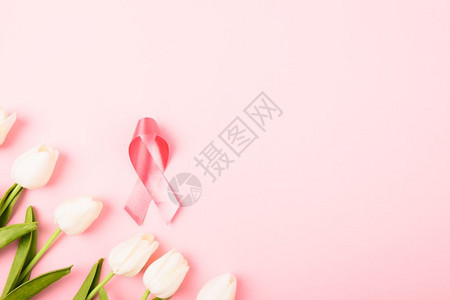 乳癌月概念平面顶楼粉红丝带和图利普花粉红背景复制文本空间图片