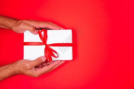 新年快乐圣诞20年或情人节顶视手与白色礼品盒红背景复制您文本的空间图片