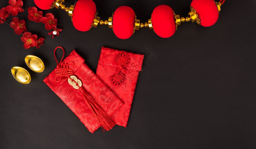 新年概念平坦的面观带着红色信封与金币CharacterFU的新年快乐代表财富祝福在黑色背景上图片