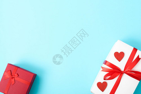 情人节概念顶视平板礼品盒和红心放在蓝背景的色上并附文本的复制空间图片
