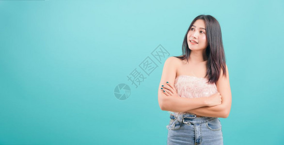 亚洲快乐的肖像亚洲美丽的年轻女士站着笑白牙的美丽年轻女士她举起双臂站在蓝色背景的一边复制文本空间图片