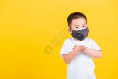 身戴面具保护罩的亚洲泰国快乐肖像可爱的小快乐男孩他用清洁的凝胶洗手背景图片