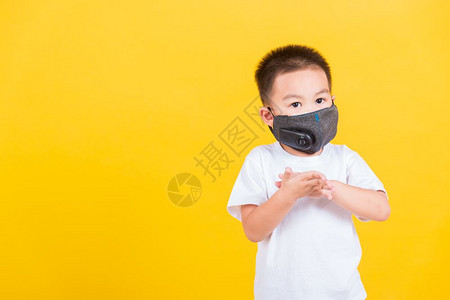 身戴面具保护罩的亚洲泰国快乐肖像可爱的小快乐男孩他用清洁的凝胶洗手图片