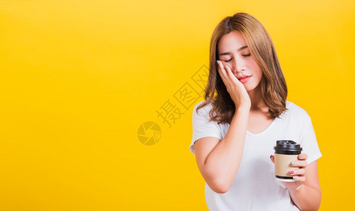 亚洲美丽的泰国快乐女士站着疲倦困无法醒来闭上眼睛将咖啡杯拿掉图片