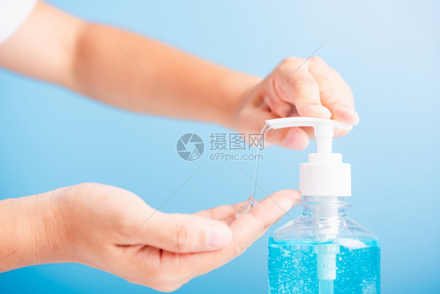 近身亚洲年轻女使用新闻喷洒机净化剂酒精凝胶泵洗手清洁卫生预防COVID19或蓝底隔离的冠状保护概念图片