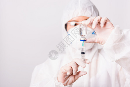 医生或科学家持有药品液体疫苗瓶子和注射器冠状或COVI图片