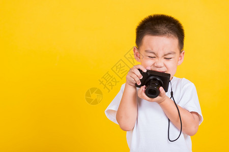 小男孩拿着照相机拍照图片
