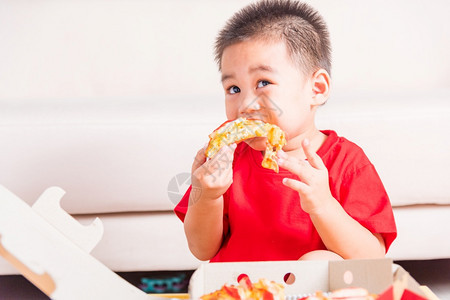 热自制蔬菜快意大利食品可爱的小孩享受吃着送披萨辣椒尼奶酪很多美味的切片在家里一个开着的纸箱里图片